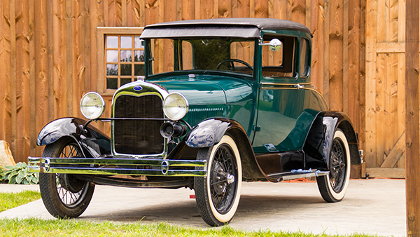 An antique car parked in front of a building.