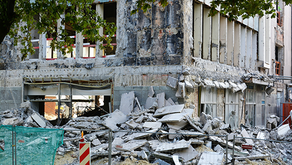 A masonry building with rubble in front of it.