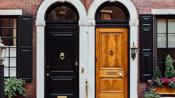 Two residential doors side by side in a multi-family building.