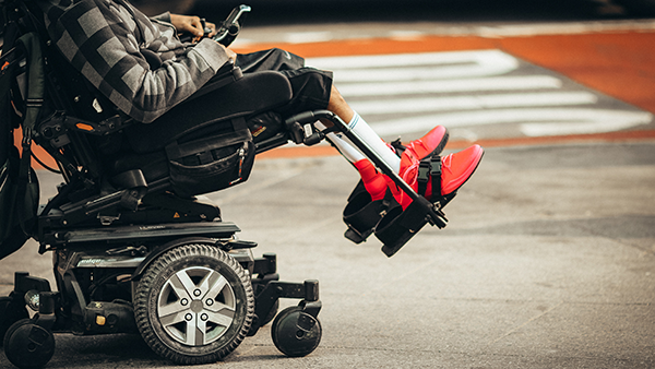 A disabled person operating a motorized wheelchair.