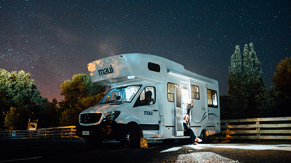 A motorhome with a starry sky in the background.