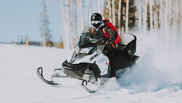 A rider operating a snowmobile in the snow