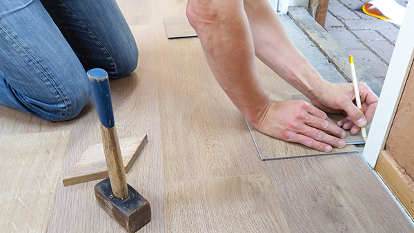 A worker installing flooring.