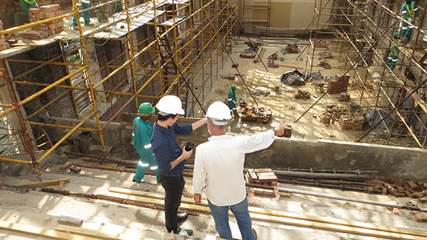 Multiple workers with hard hats on a construction site.