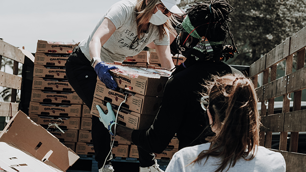 Volunteers working together to move boxes of food.