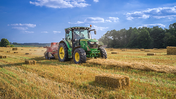 A tractor baling hay in