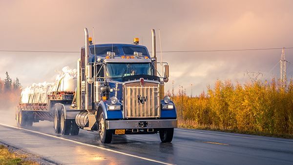 A semi-truck on the road carrying a load