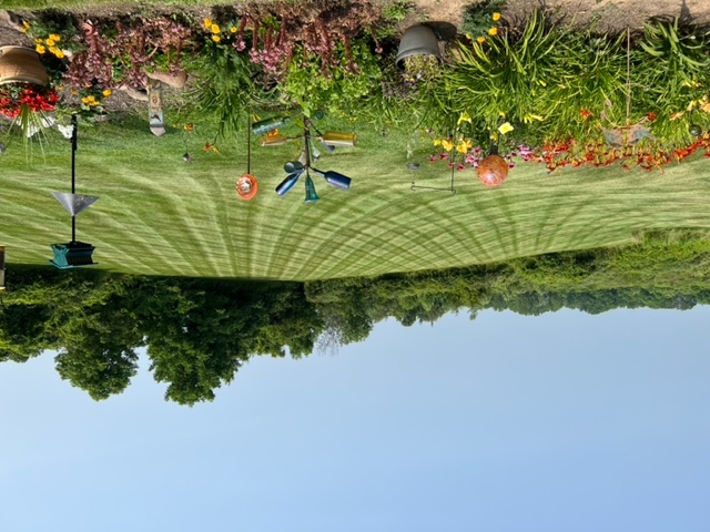 A flower garden with a lawn behind. The lawn is mowed with straight lines.